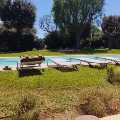 Area relax con lettini prendisole accanto alla piscina privata immersa nel giardino mediterraneo di Villa Agapanthus, a Monopoli