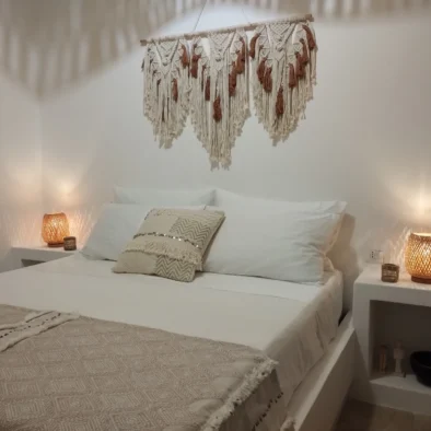 Camera da letto in stile boho chic con dettagli artigianali e luce soffusa a Villa