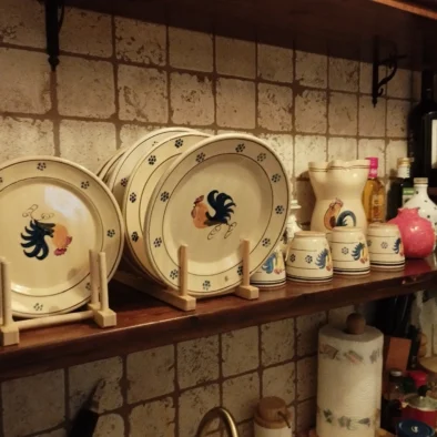 Vino, formaggi, pane di Altamura e conserve disposti su mensola rustica nella cucina di Villa Agapanthus
