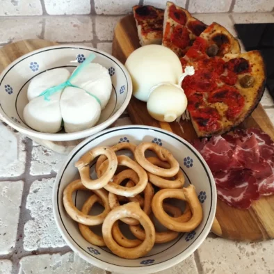 Degustazione di prodotti tipici pugliesi: taralli, mozzarella, cipolla, focaccia e salumi serviti nella cucina di Villa Agapanthus