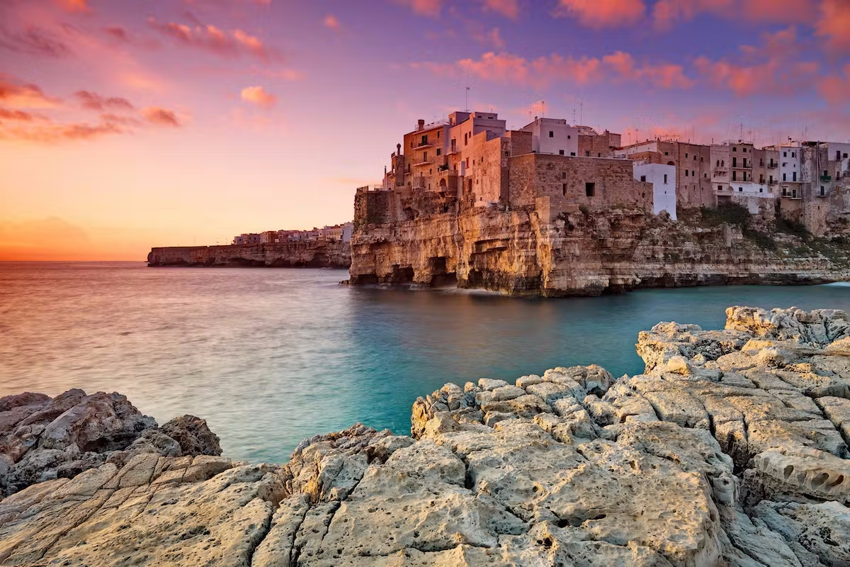 Polignano a Mare al tramonto, uno dei luoghi più suggestivi vicino a Villa Agapanthus, casa vacanze a Monopoli, ideale per vacanze in Puglia con esperienze enogastronomiche e comfort di lusso.