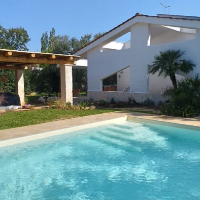 Piscina privata con vista sulla villa e giardino mediterraneo a Monopoli