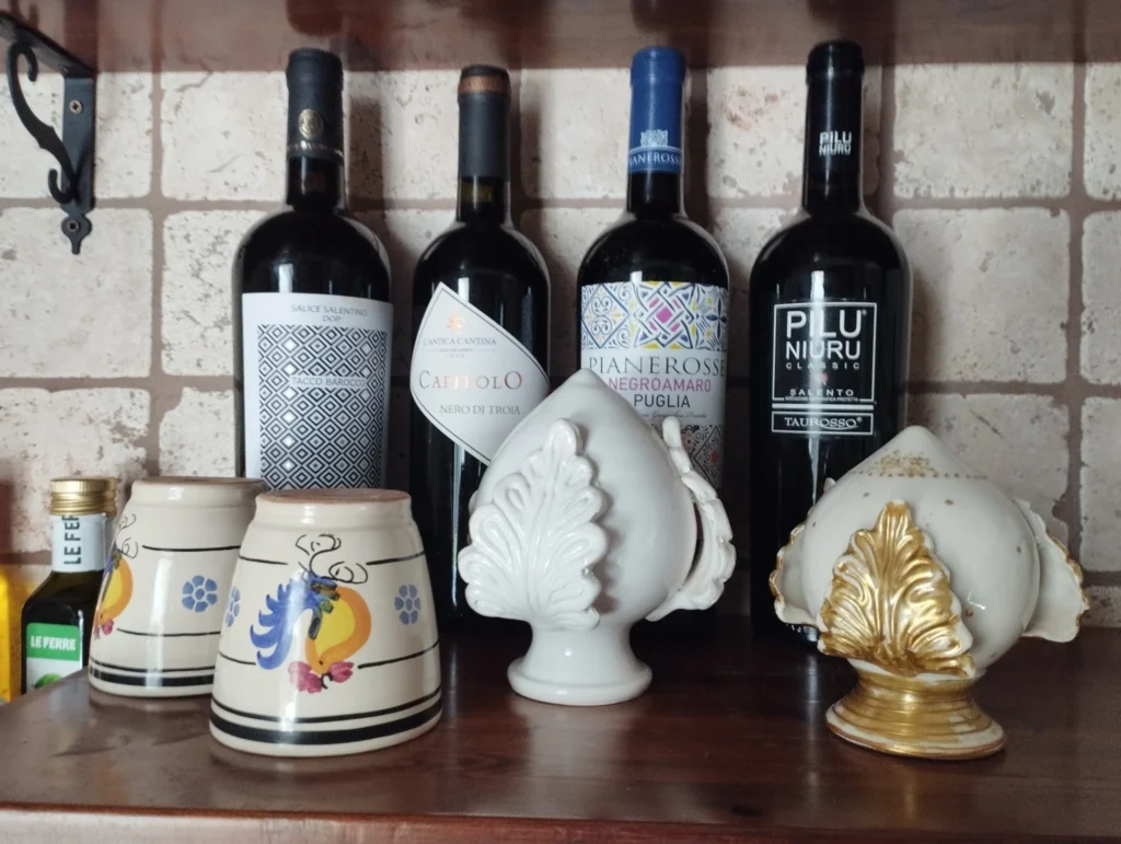 Bottiglie di vino pugliese e ceramiche artigianali esposte nella cucina in pietra della Villa Agapanthus a Monopoli