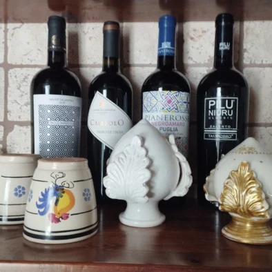 Bottiglie di vino pugliese e ceramiche artigianali esposte nella cucina in pietra della Villa Agapanthus a Monopoli