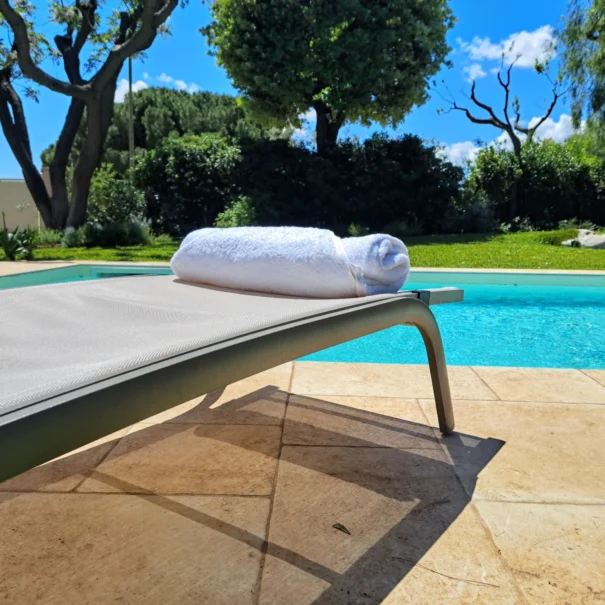 Lettino con asciugamano bianco a bordo piscina privata nella Villa Agapanthus a Monopoli