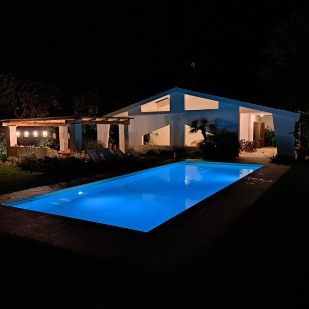 Villa Agapanthus con piscina privata e cucina esterna illuminate in una serata d’estate a Monopoli
