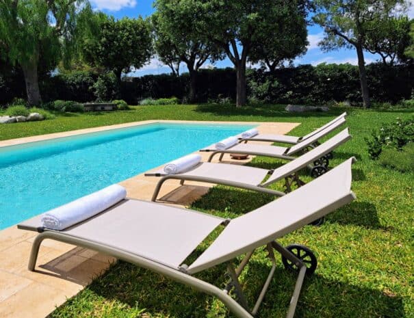 Sun loungers by the private pool surrounded by garden in Monopoli