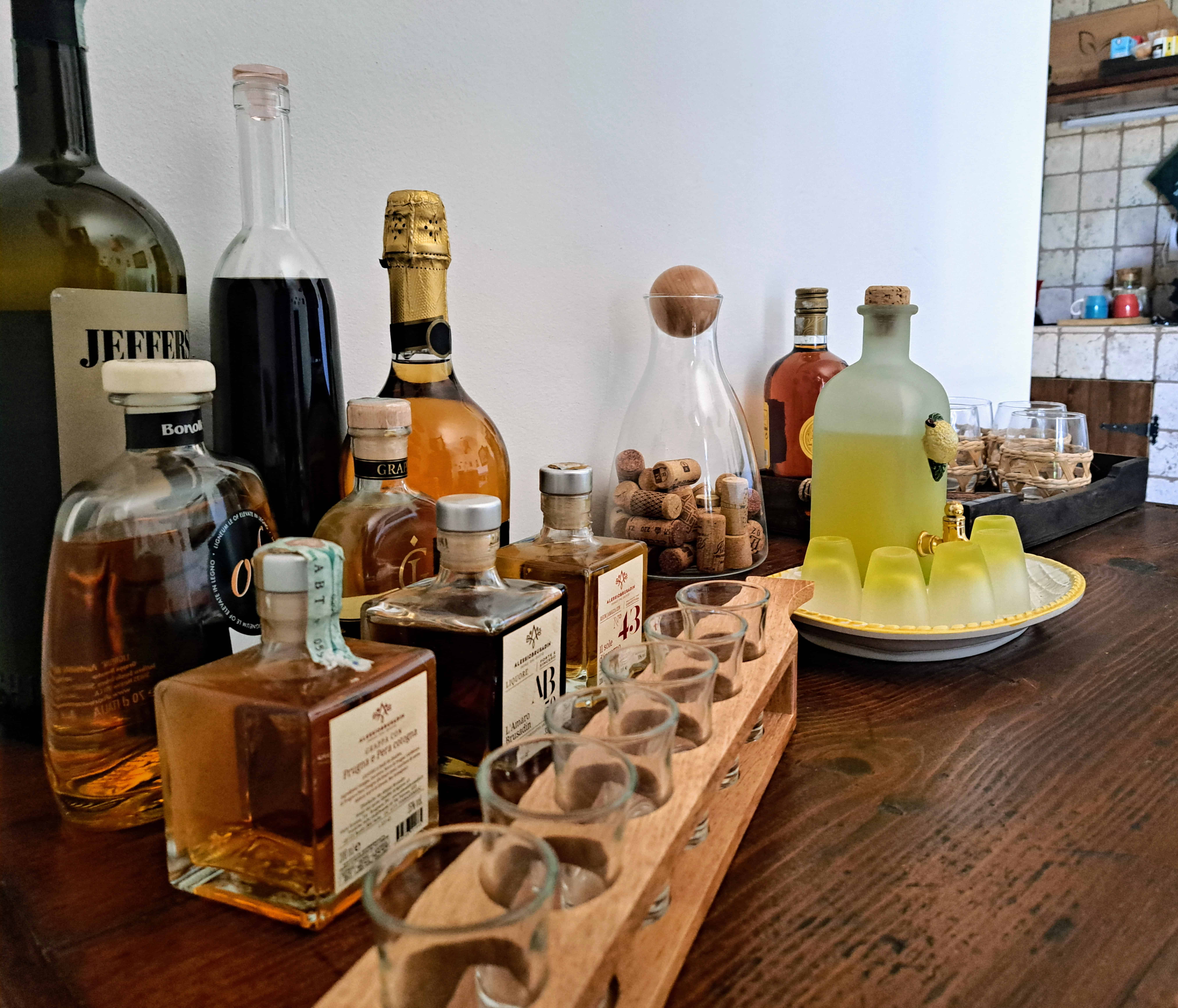 Bottiglie di rum, grappa, limoncello e amari con bicchierini pronti per la degustazione a Villa Agapanthus